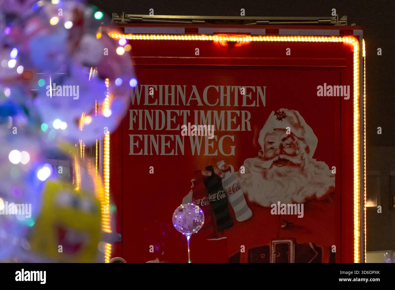 Un furgone Coca-Cola porta un cartello natalizio illuminato da luci festive, Austria, Vienna, 13 dicembre 2024 Foto Stock