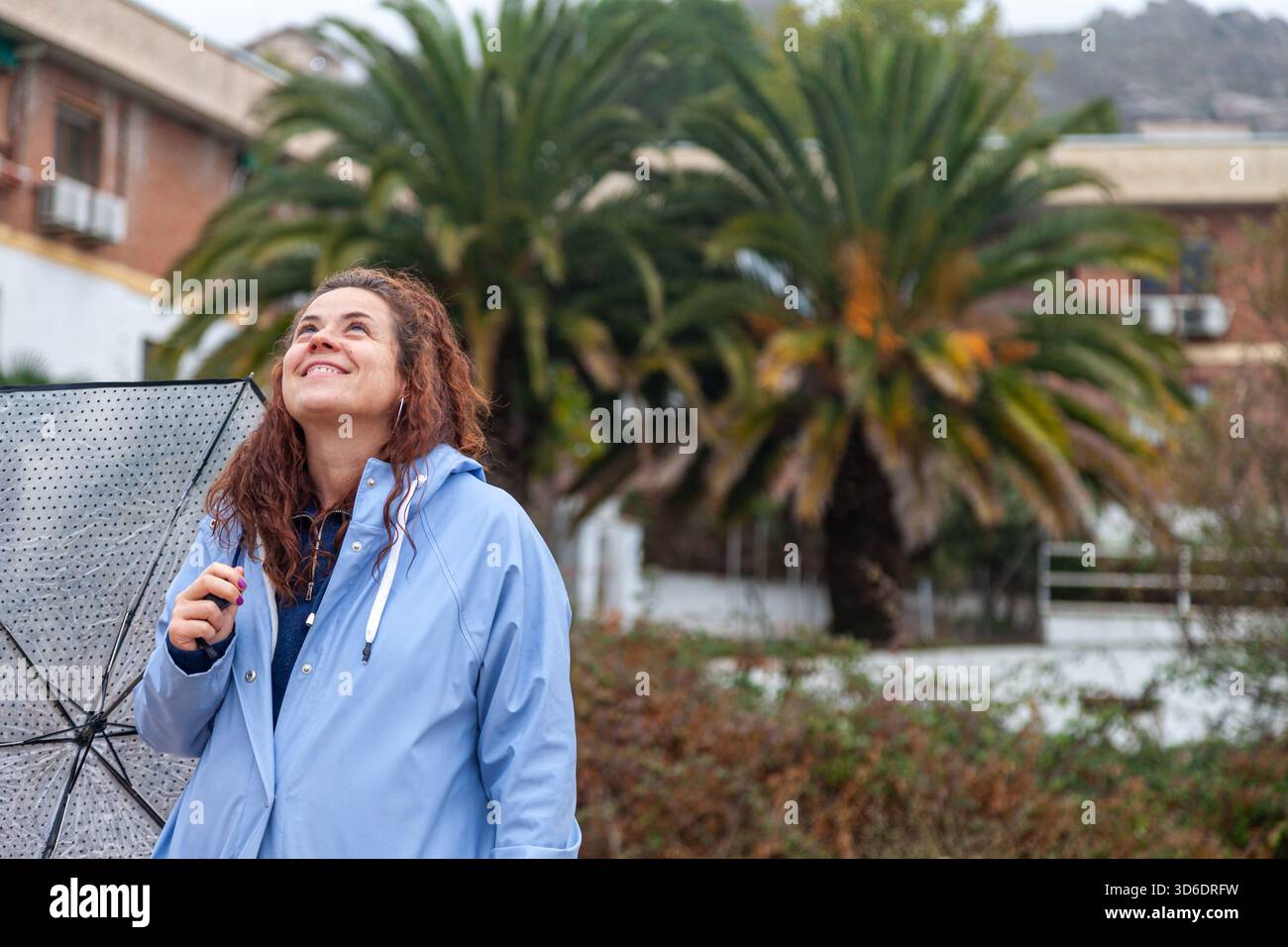 Ritratto autentico di donna che cammina nella pioggia con giacca Blue Rain Foto Stock
