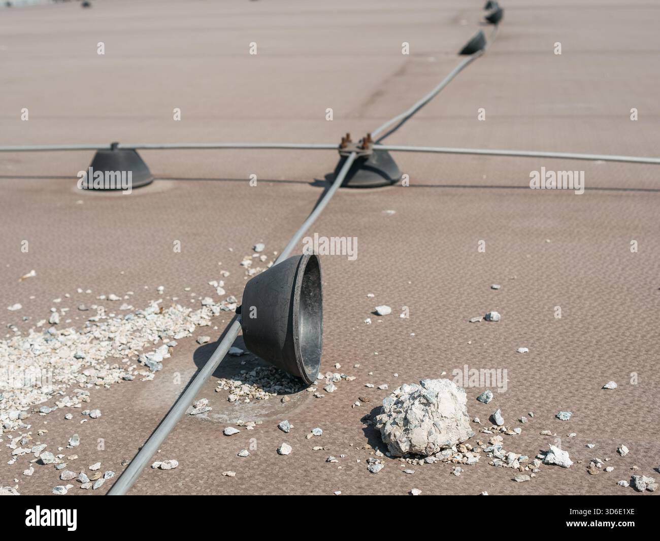 Il calcestruzzo di bassa qualità deteriorato è caduto dalle basi di peso dell'asta di fulmine sul tetto, rivelando il decadimento strutturale e i problemi di sicurezza sulla b Foto Stock