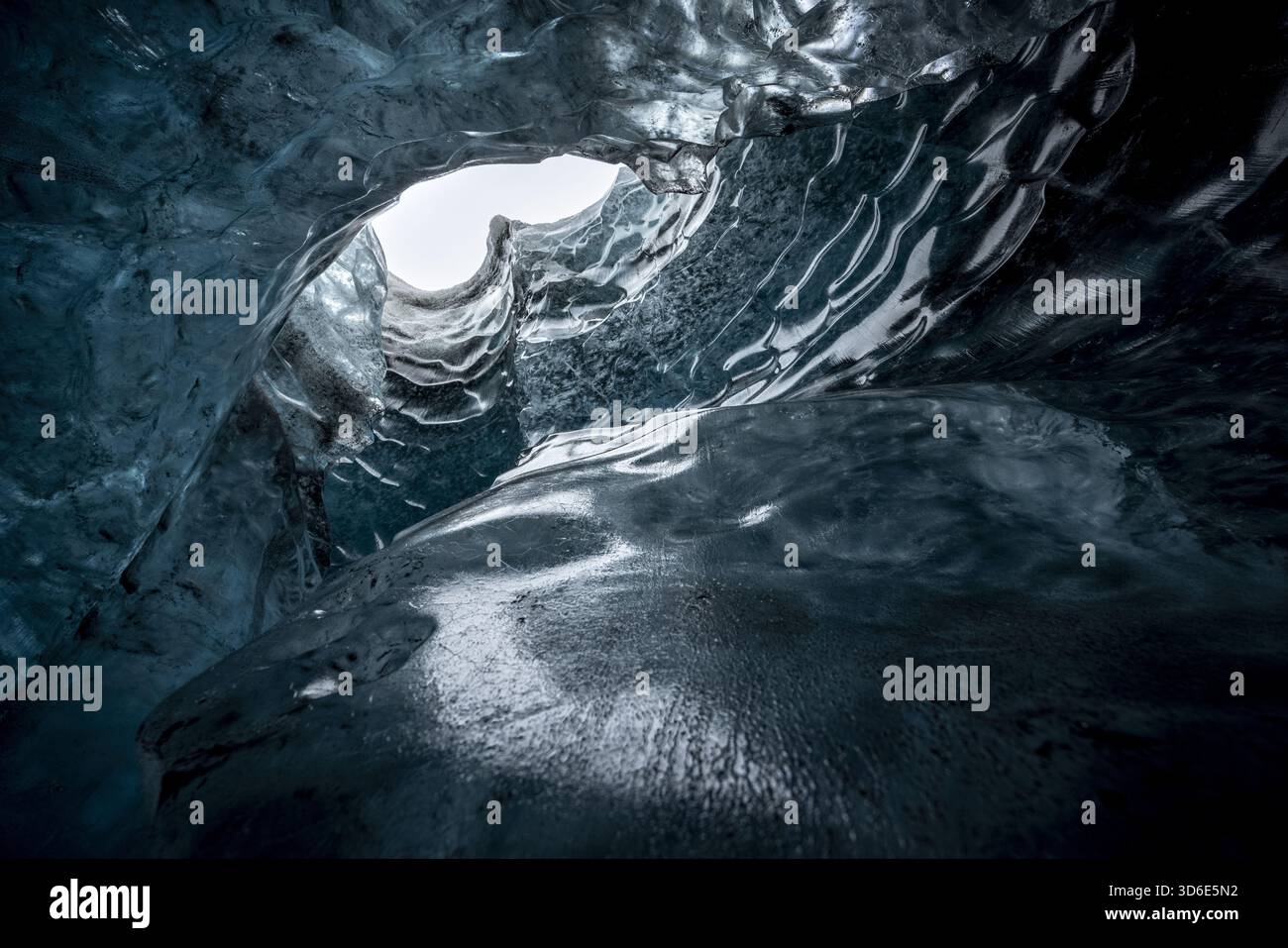 Vista delle eteree formazioni di ghiaccio blu scolpite dal tempo e dalla natura, rivelando uno sguardo di luce del giorno, a Vatnajokull, Islanda. Foto Stock