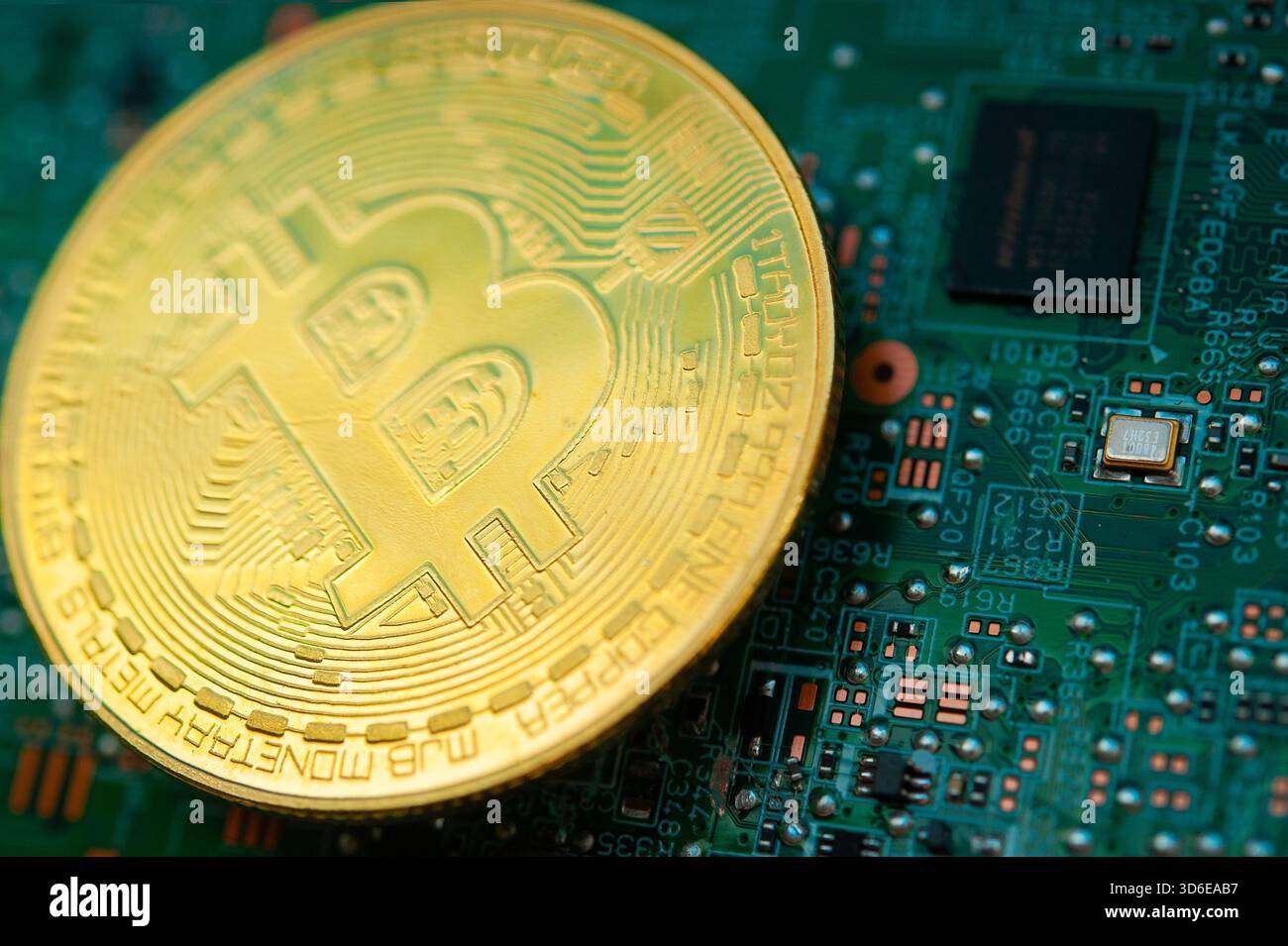 Moneta Bitcoin d'oro su una scheda madre per computer che simboleggia criptovaluta e finanza digitale Foto Stock
