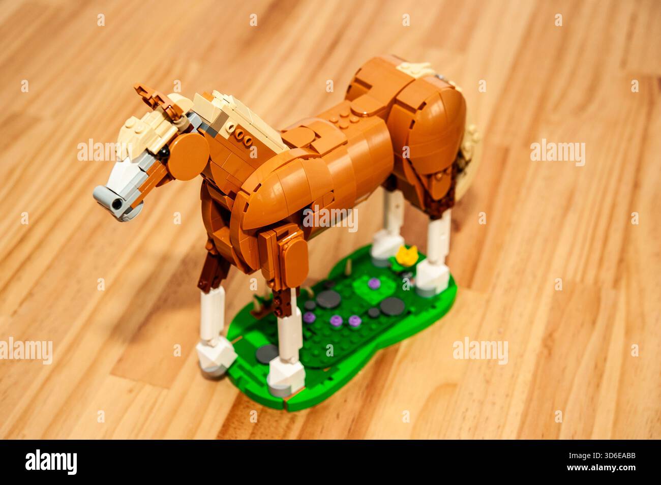 Modello di cavallo LEGO fotografato dall'alto su una superficie in legno, che mostra una dettagliata costruzione in mattoni Foto Stock