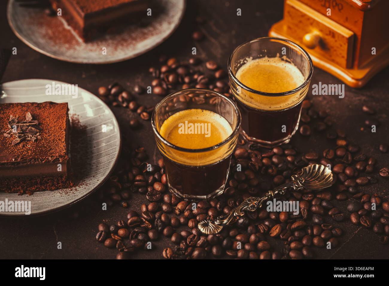 Due tazze da caffè espresso con una fetta di torta al cioccolato su sfondo marrone Foto Stock