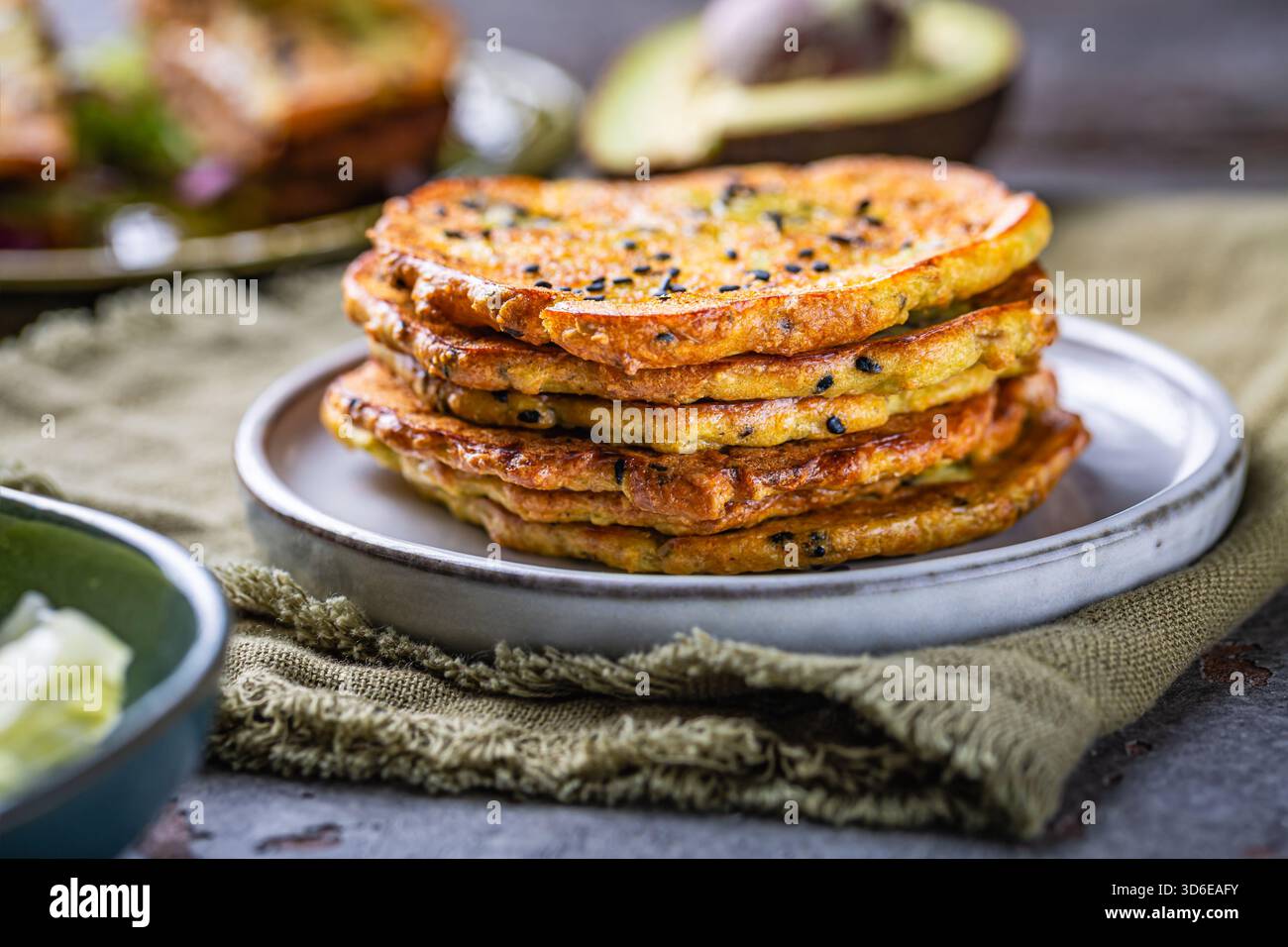 Pane piatto all'avocado senza glutine, con verdure e formaggio spalmabile, saporiti pancake all'avocado Foto Stock