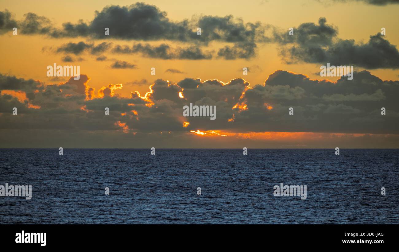 Una foto dell'atmosfera oscura mentre il sole tramonta sull'orizzonte dell'oceano Foto Stock