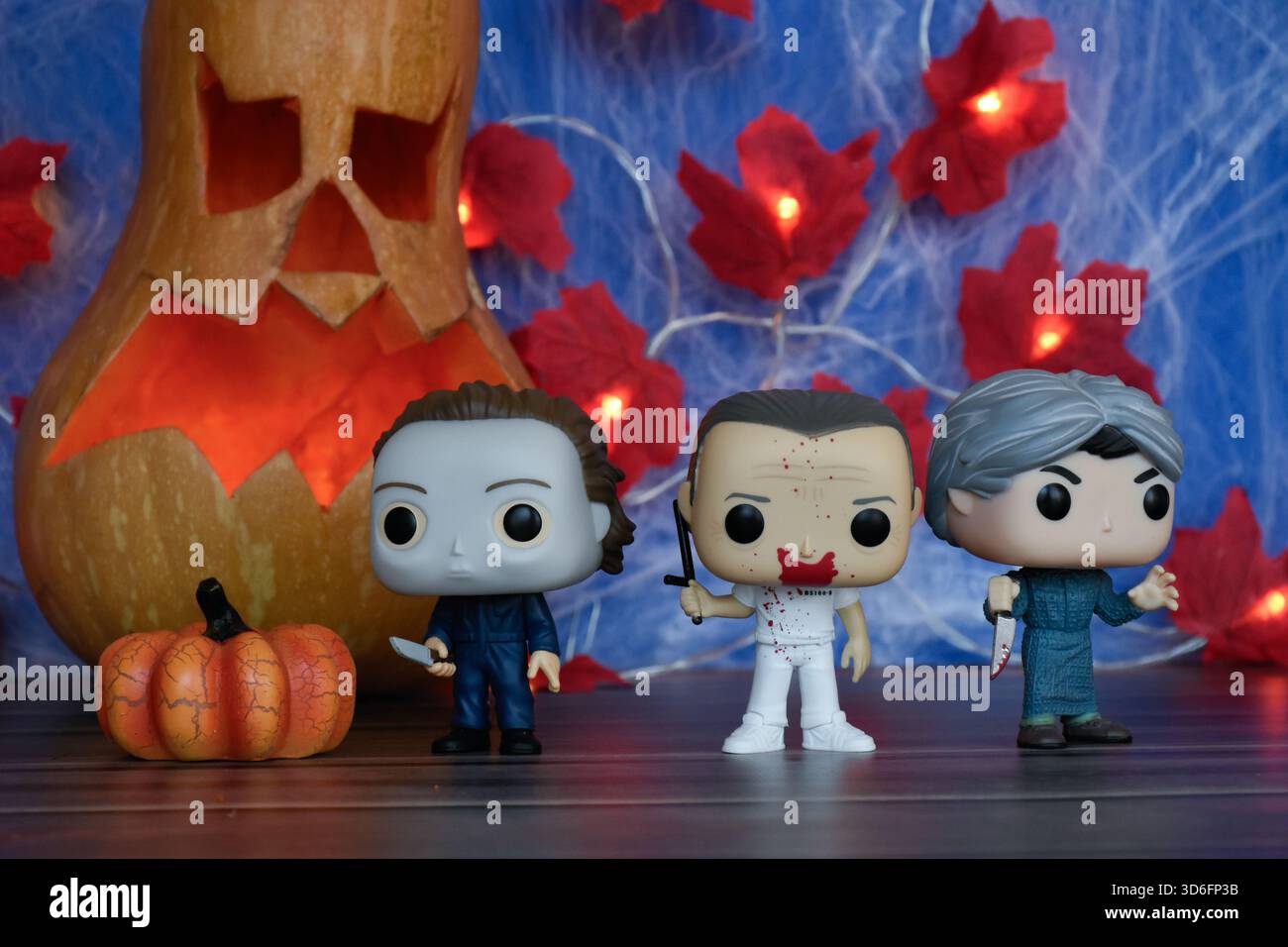 Funko Pop action figure dei personaggi horror Michael Myers, Hannibal Lecter e Norman Bates. Halloween, Jack o lanterna, ragnatela, foglie, luci. Foto Stock