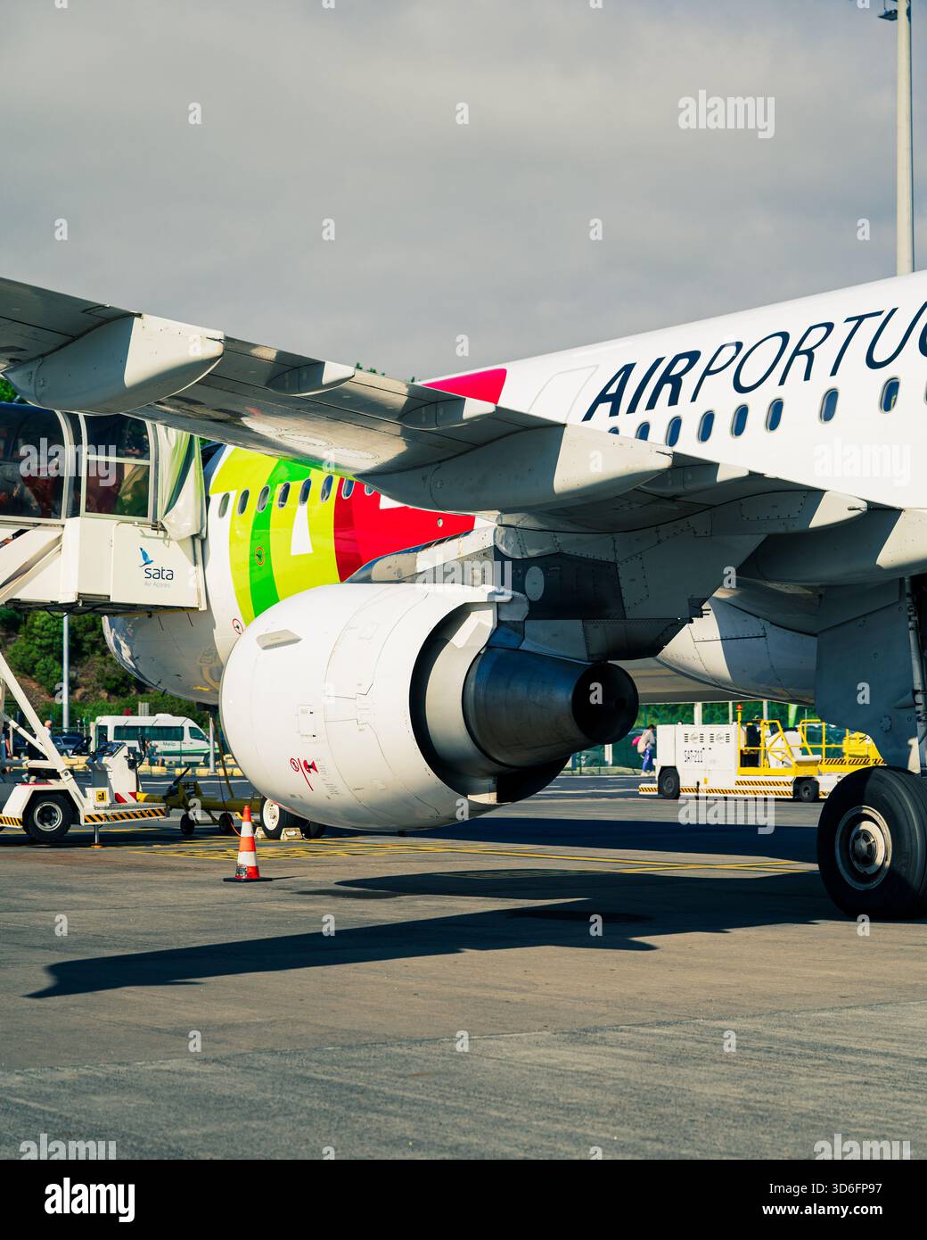 Azzorre - Aeroporto di Ponta Delgada: Primo piano di un aereo di Air Portugal sulla pista, evidenziando l'ala, il motore e il carrello di atterraggio con il personale di terra Foto Stock