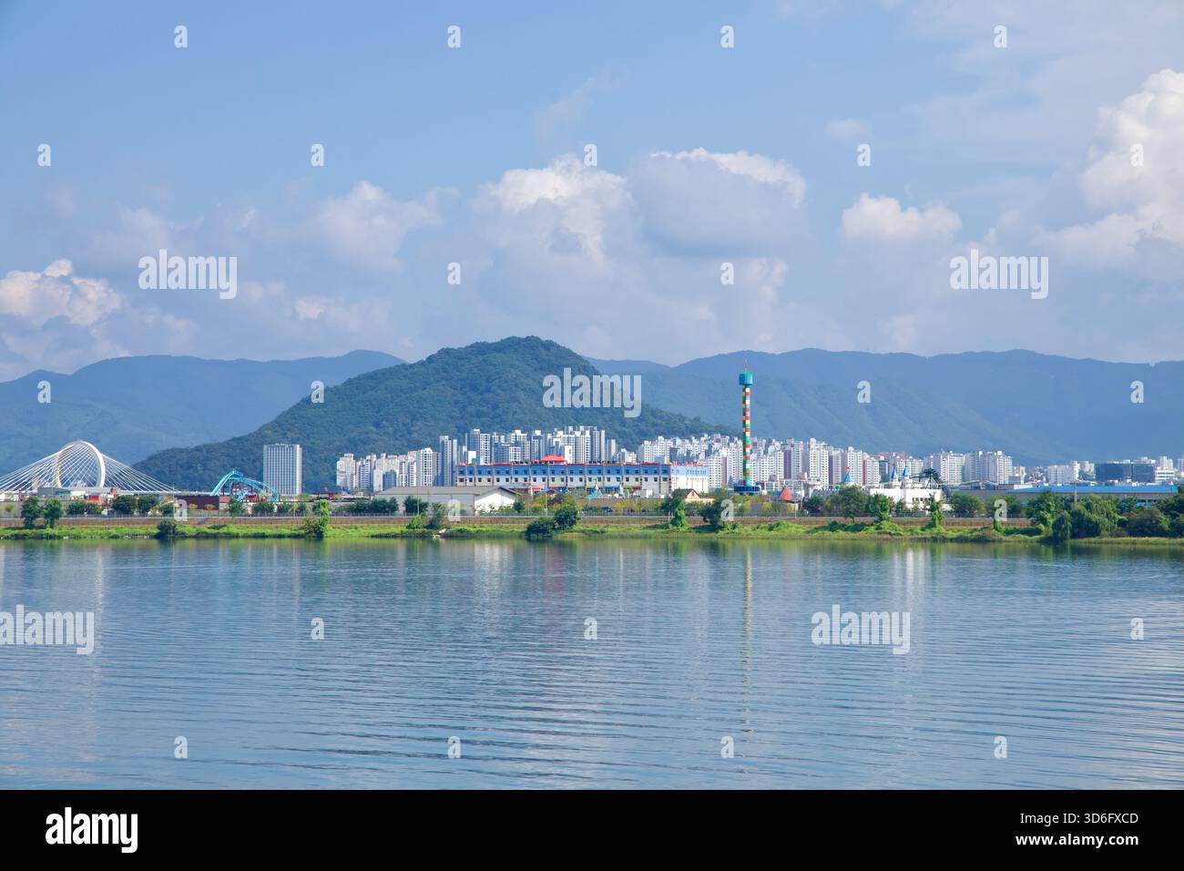 Attraverso il tranquillo lago Uiam, lo skyline di Chuncheon incornicia l'isola di Hajungdo con la colorata torre di osservazione di Legoland Korea e l'arco bianco di Chuncheon Gra Foto Stock