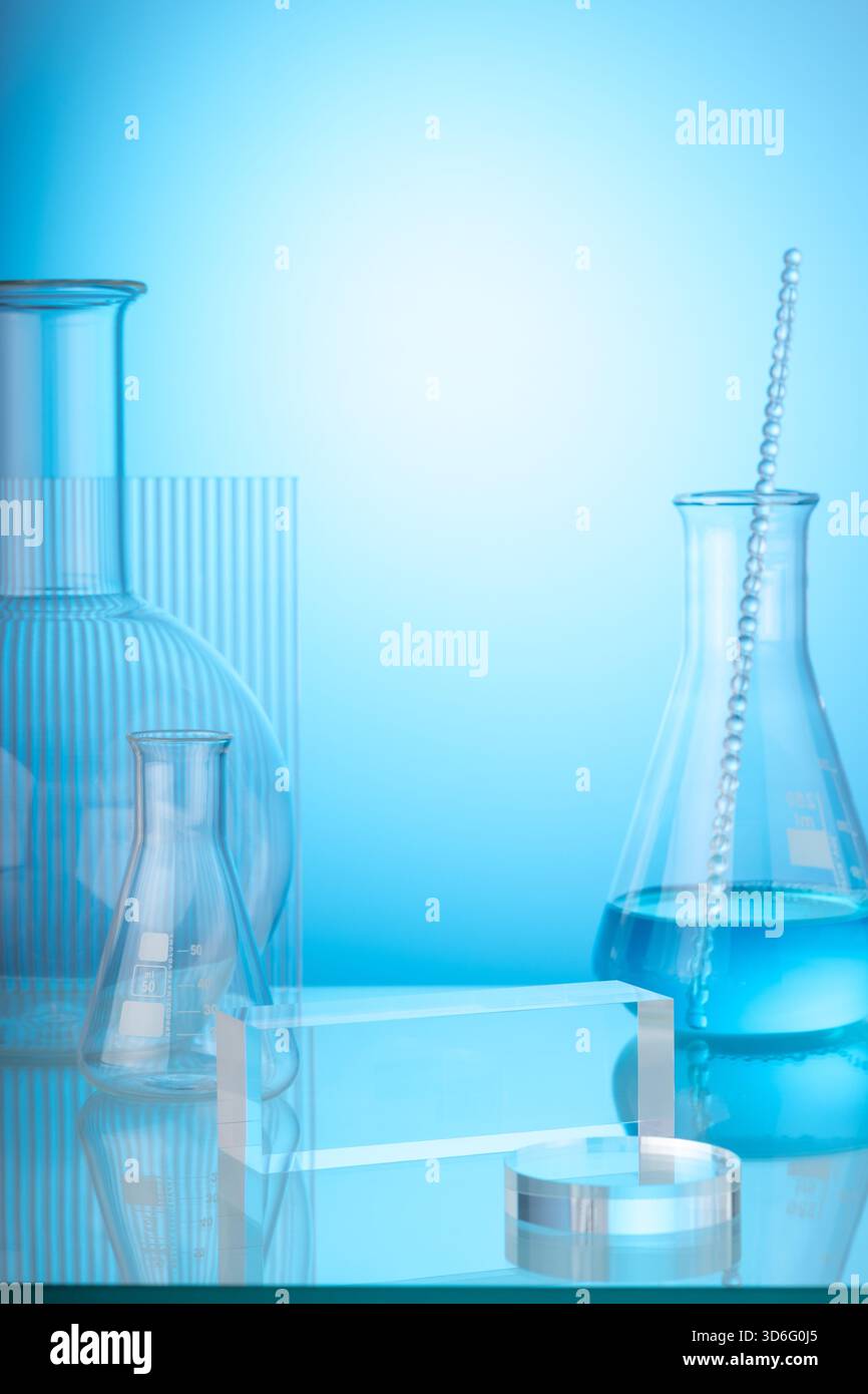 Background scientifico e medico con vetreria da laboratorio riempita di liquido blu e foglio acrilico a coste decorato su sfondo azzurro. Spazio per i prodotti p Foto Stock