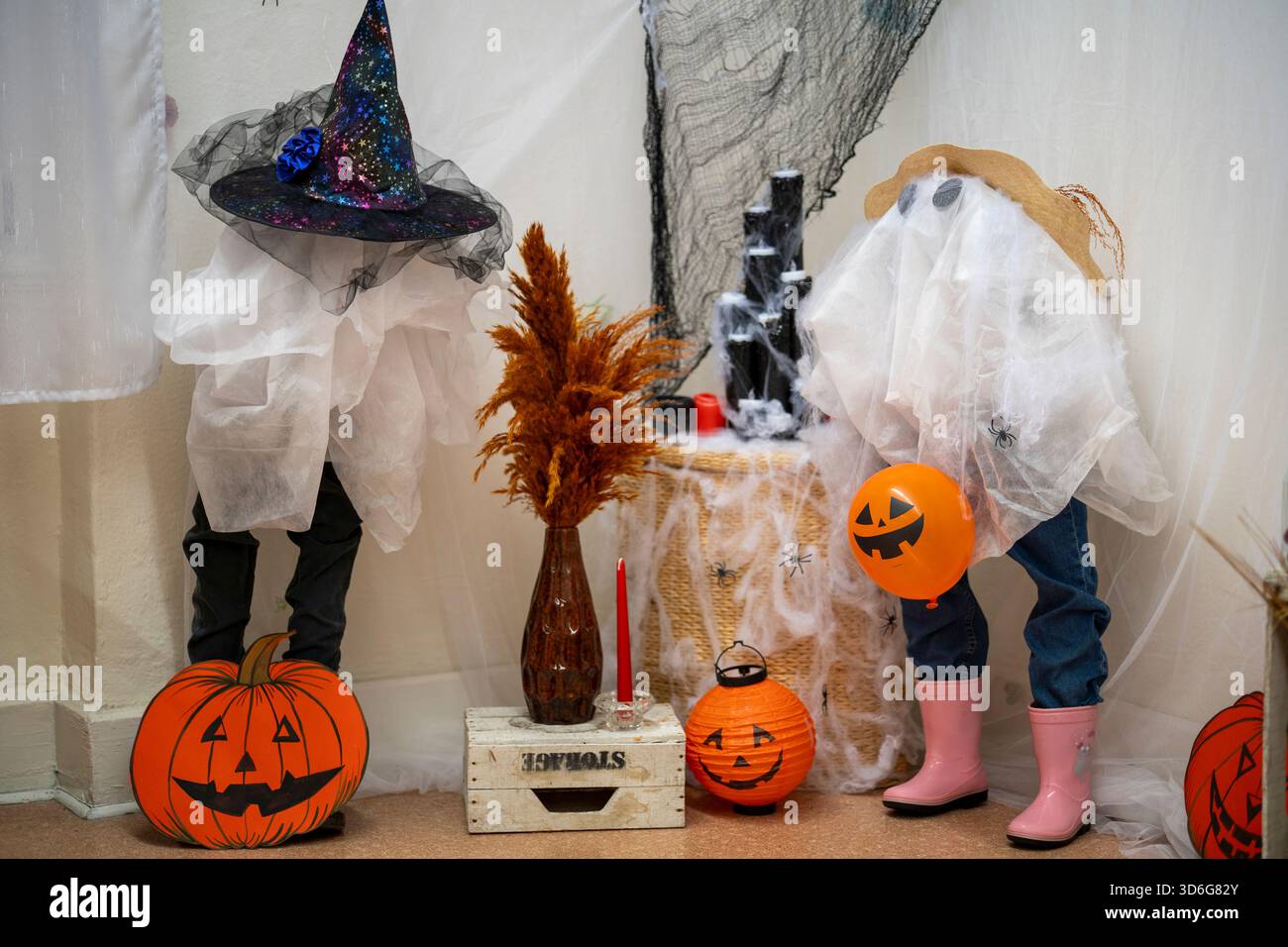 Decorazioni di Halloween su un tavolo di legno con zucche, fantasmi, cappelli da streghe, candele e foglie d'autunno che creano un'atmosfera festosa e spettrale. Halloween Foto Stock