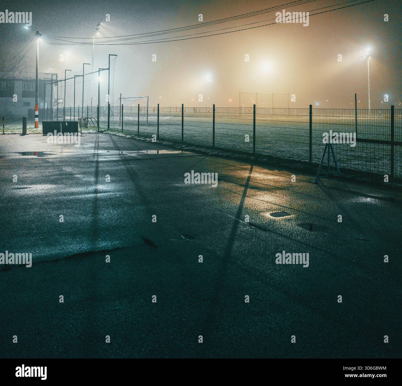 Scena notturna di campi da calcio con giocatori in autunno, atmosfera nebbiosa. Foto Stock