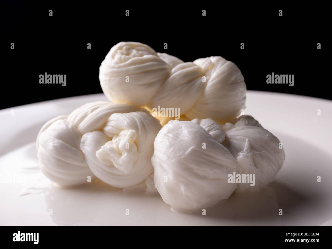 Macro shot di nodi freschi di mozzarella bianca (Treccia), che mostrano una trama intrecciata cremosa. Foto Stock