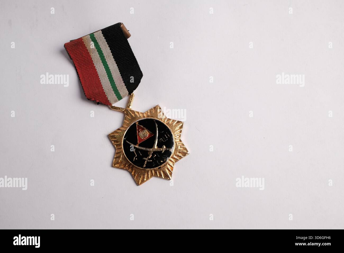 Una medaglia militare con un nastro a strisce rosse, bianche, verdi e nere. Foto Stock