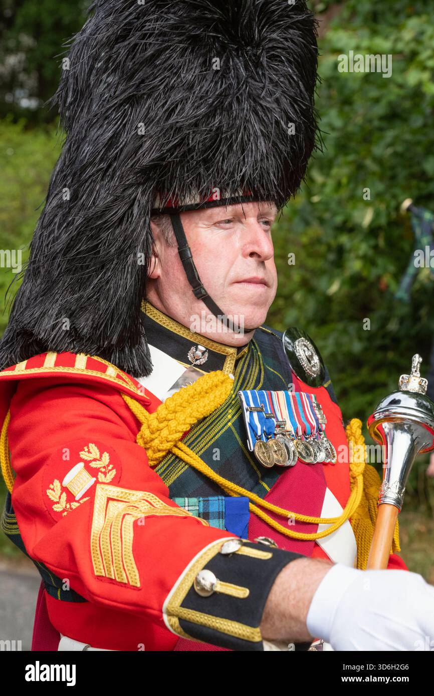 Un Drum Major dirige la Lonach Pipe Band al Lonach Gathering del 2025 Foto Stock