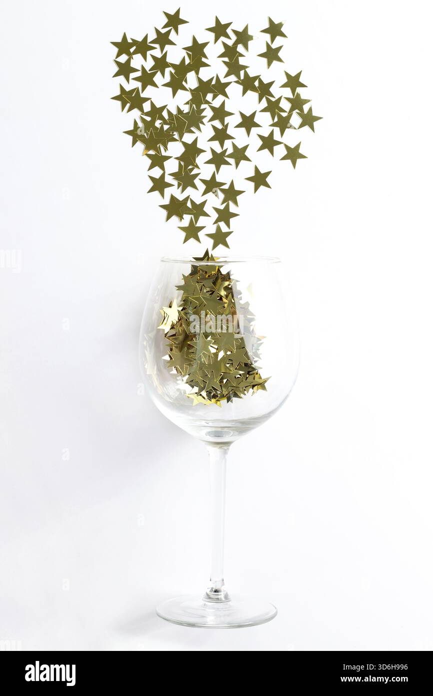 Cibo, bicchiere di champagne con piatti natalizi versava coriandoli di stelle dorate con spazio per copiare. Sfondo vista dall'alto anno nuovo Foto Stock