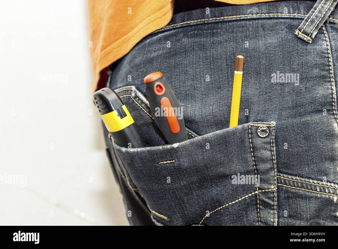 Cibo, attrezzatura ingegneristica nella tasca posteriore dei jeans. cacciavite a matita, martello e coltello Foto Stock