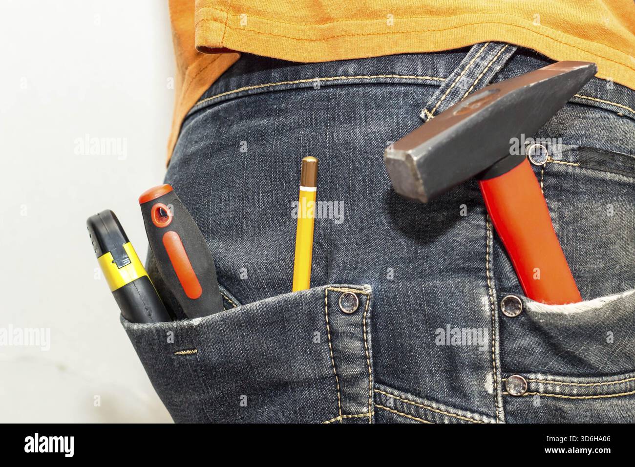 Cibo, attrezzatura ingegneristica nella tasca posteriore dei jeans. cacciavite a matita, martello e coltello Foto Stock