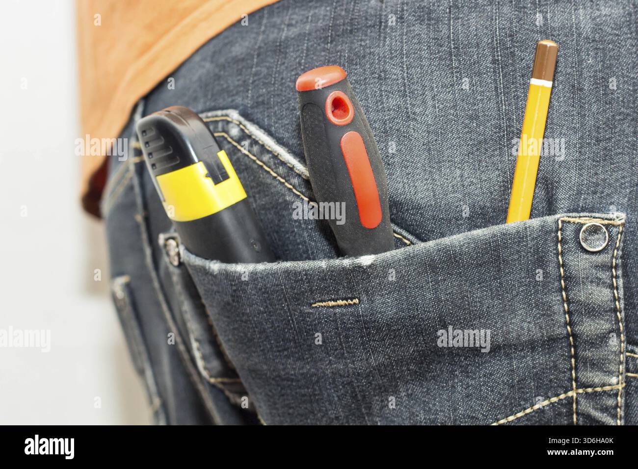 Cibo, attrezzatura ingegneristica nella tasca posteriore dei jeans. cacciavite a matita, martello e coltello Foto Stock