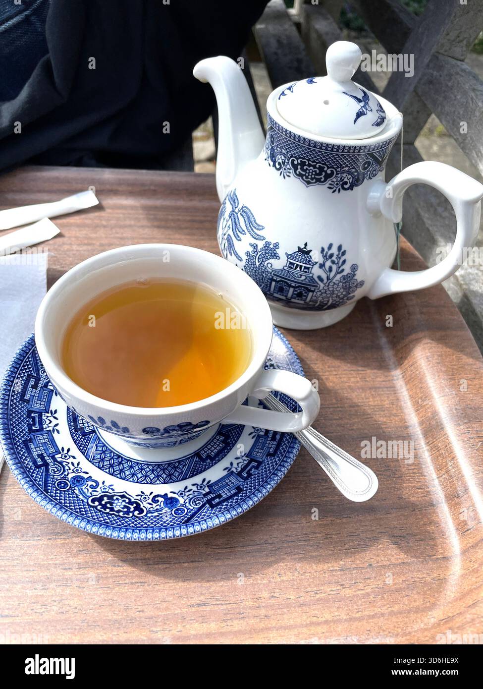 Tazza di tè con vista dall'alto servita in tradizionale porcellana blu e bianca con teiera coordinata su vassoio di legno all'aperto Foto Stock