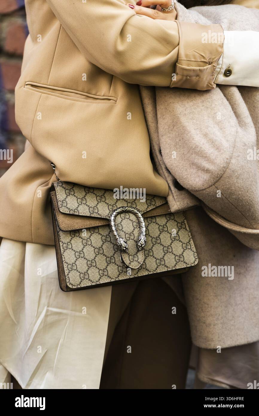 Milano, Italia - 21 settembre 2022: Donna che indossa giacca blazer beige, tracolla Dioniso GG Supreme con motivo a stampa beige e marrone da Gucci Foto Stock