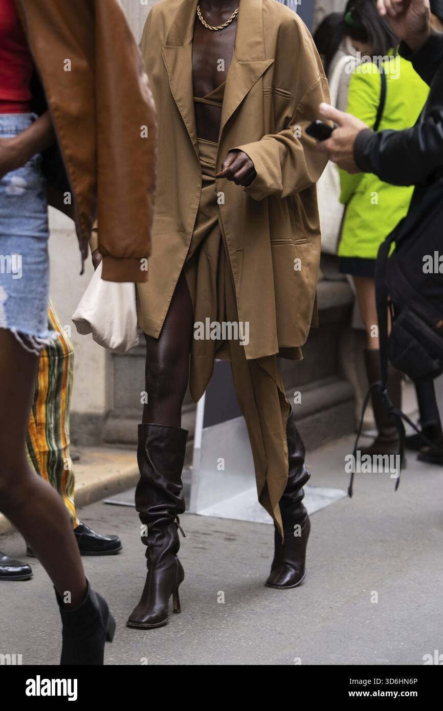 Milano, Italia - 21 settembre 2022: Donne alla moda che indossano camice marrone, gonna coordinata e crop top, stivali in pelle con tacco alto marrone, beige tenente Foto Stock