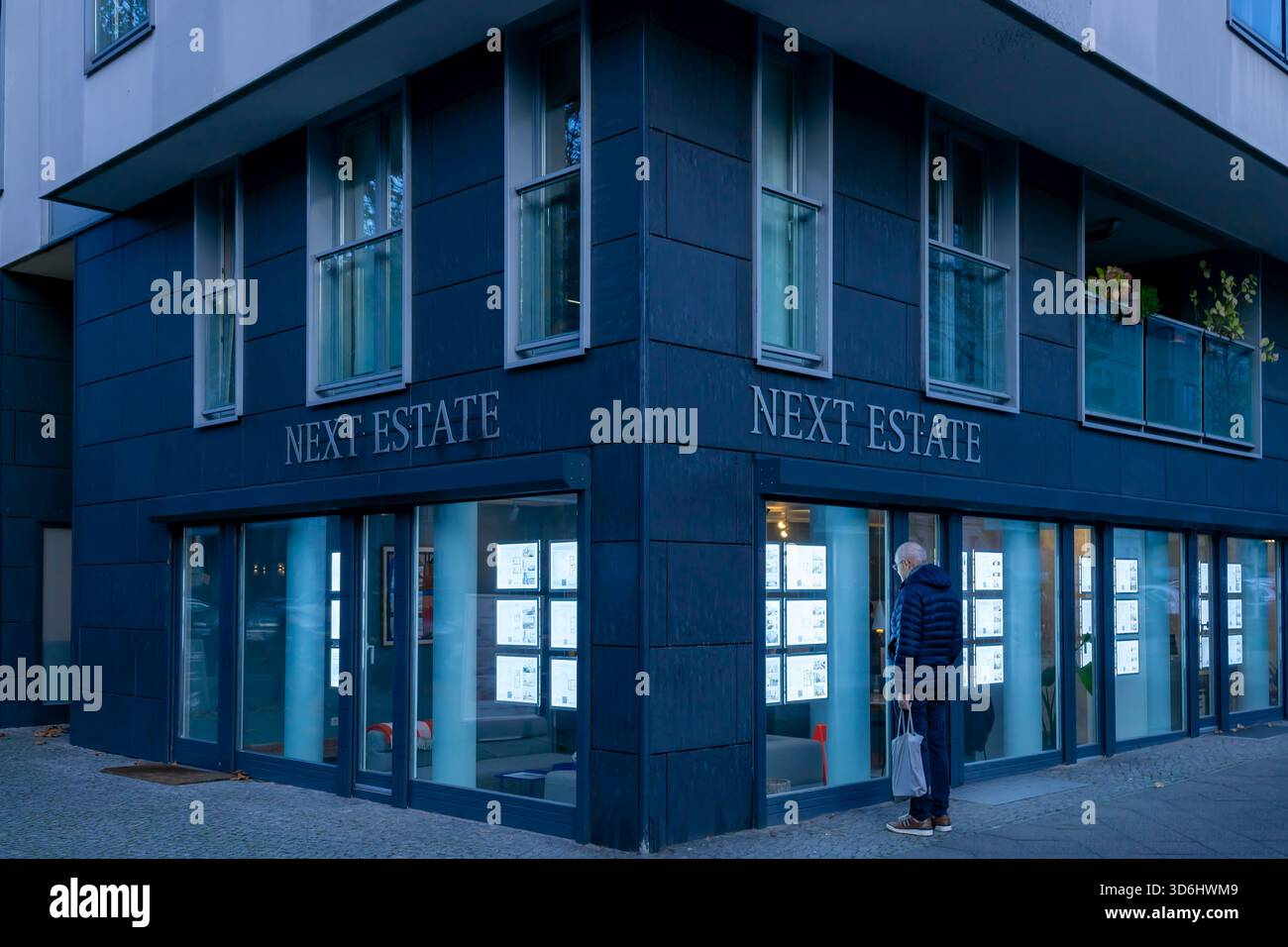Vista serale dall'ufficio immobiliare illuminato "Next Estate" fotografato durante l'ora blu a Berlino. Foto Stock