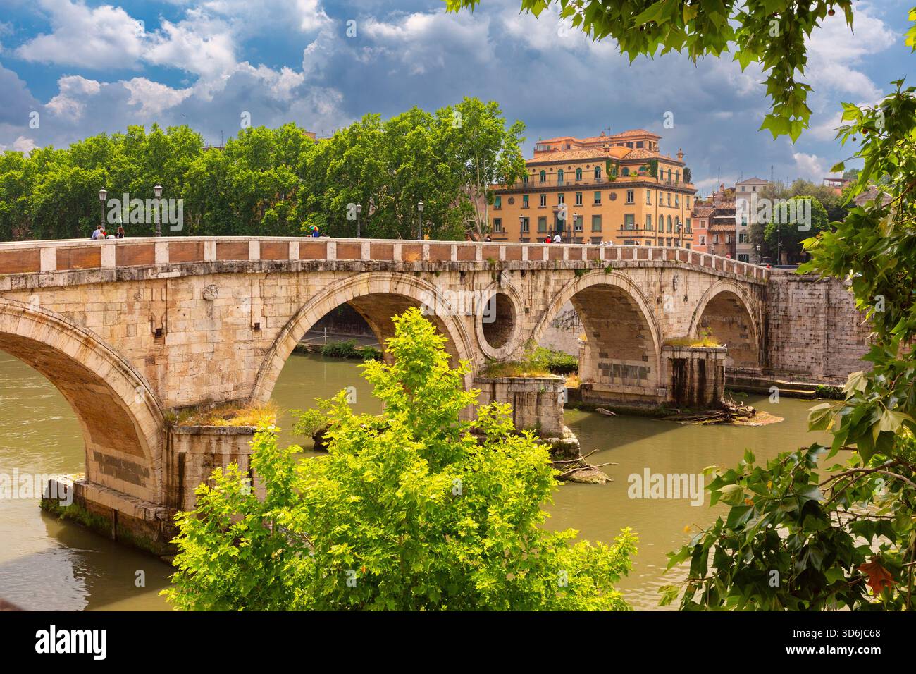 Storico ponte Sisto che attraversa il fiume Tevere con alberi ed edifici a Roma, Italia Foto Stock