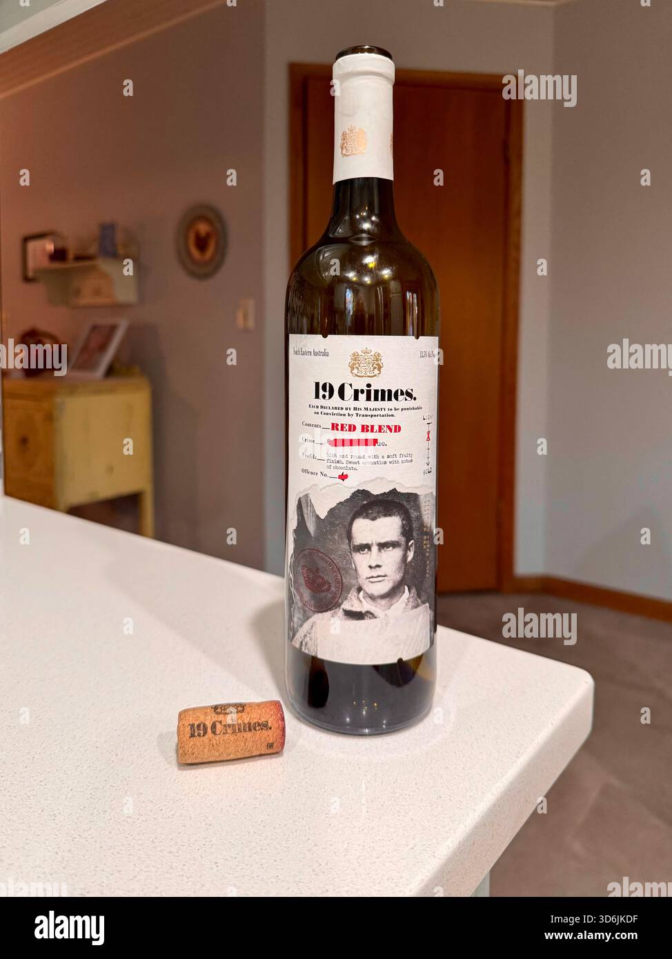 19 bottiglie di vino crimini sedute sul bordo di un bancone della cucina con l'etichetta che mostra una foto di un uomo. STATI UNITI. Foto Stock