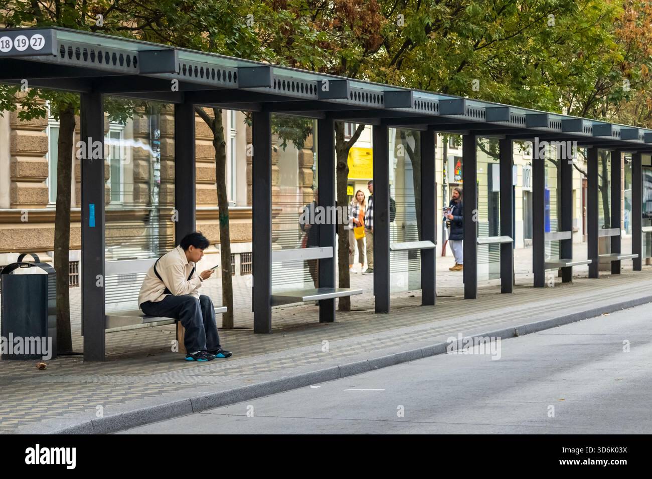Lubiana, Slovenia 19 ottobre 2025 fermata moderna dell'autobus con pannelli di vetro e panchine Foto Stock