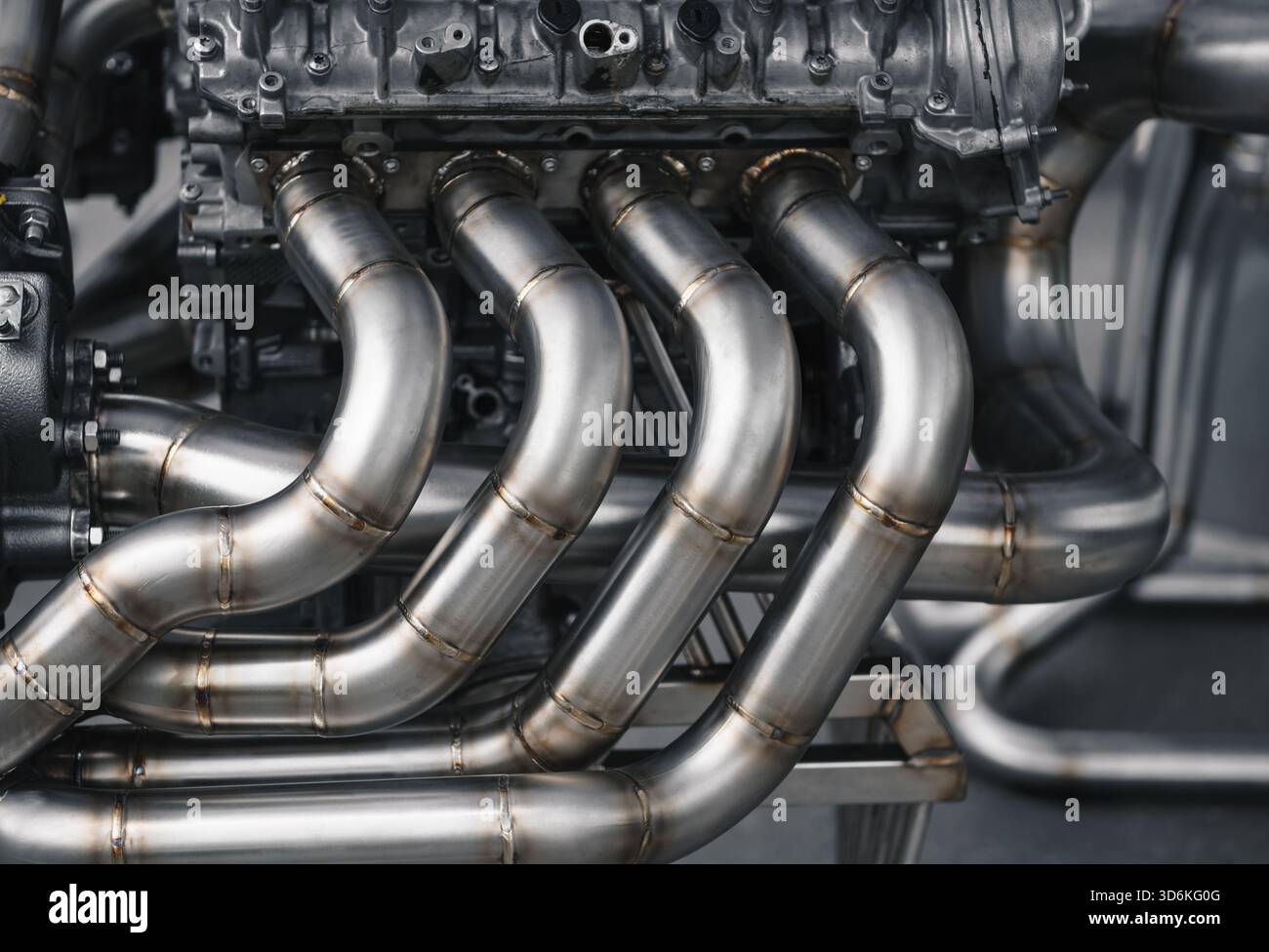 Motore V8 con scarico personalizzato. Vista ravvicinata dello scarico del motore v8 con testate personalizzate di uguale lunghezza. Vista laterale del motore grande su un cavalletto. Foto Stock