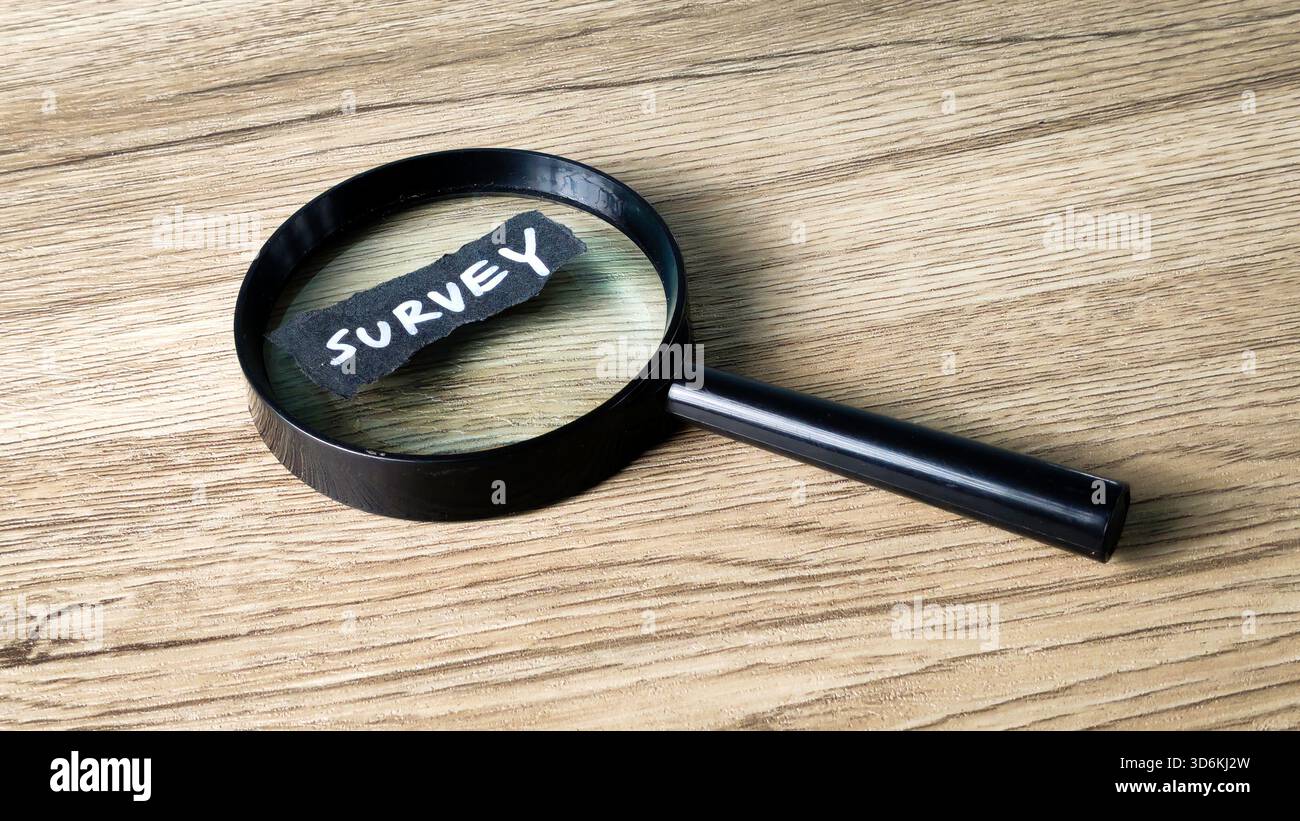 Concetto di indagine con una lente di ingrandimento che si concentra su una nota scritta a mano, simboleggia la ricerca di mercato, l'analisi approfondita dei dati e il feedback dei clienti. Foto Stock