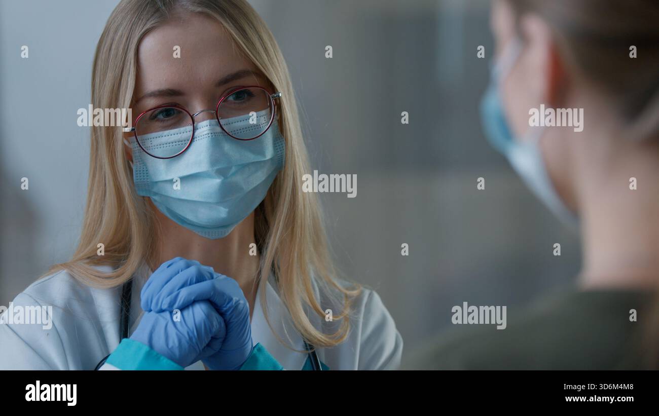 Primo piano donna caucasica dottore parlare conversazione con ragazza paziente due donne in faccia maschera medica in clinica parlare medicina consultazione Foto Stock