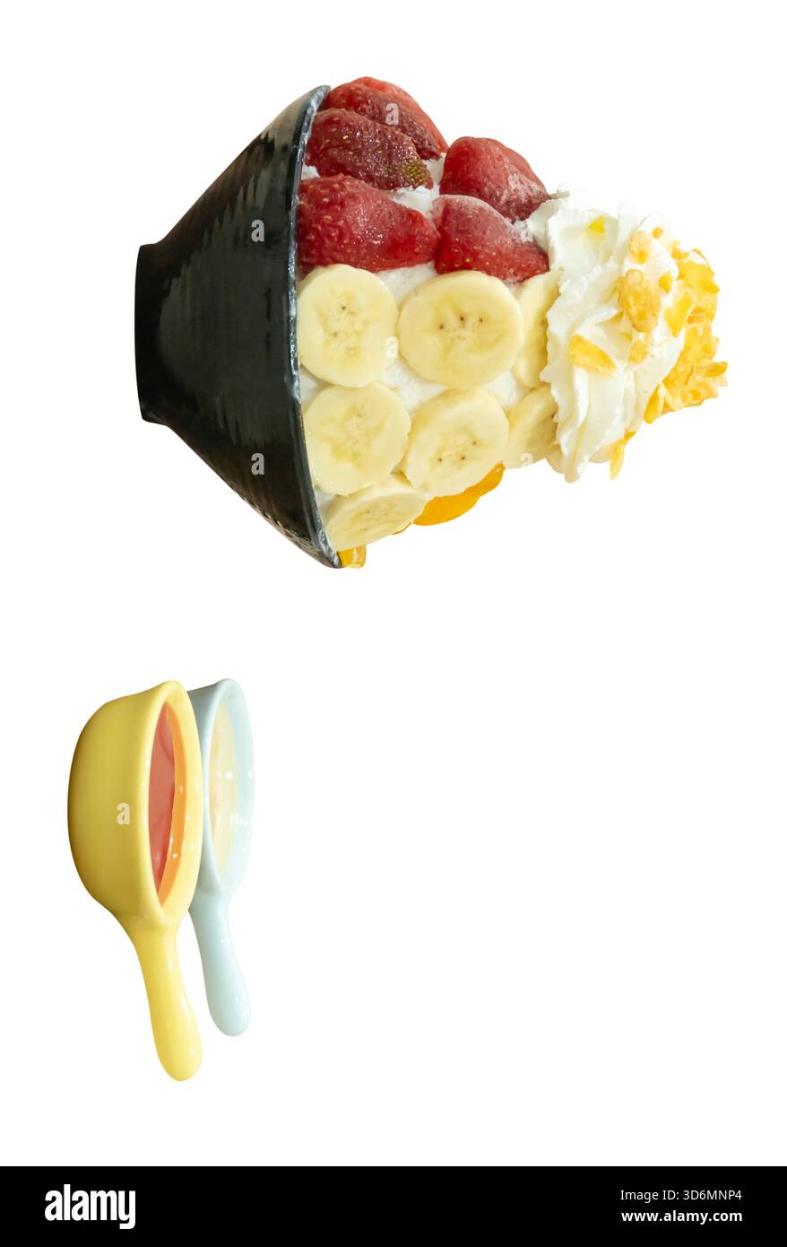 Un set di Bingsu coreano in una piccola ciotola nera con diversi condimenti di frutta e salsa rossa con latte condensato dolce in piccoli cucchiai sono isolati su bianco Foto Stock