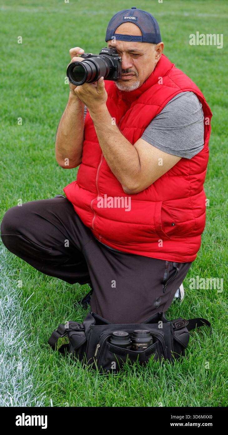 Uomo anziano che lavora come fotografo in un evento sportivo Foto Stock