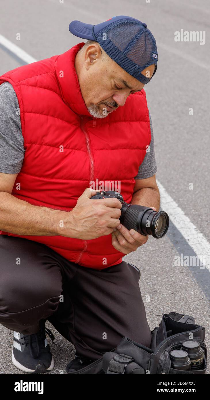 Uomo anziano che lavora come fotografo in un evento sportivo Foto Stock