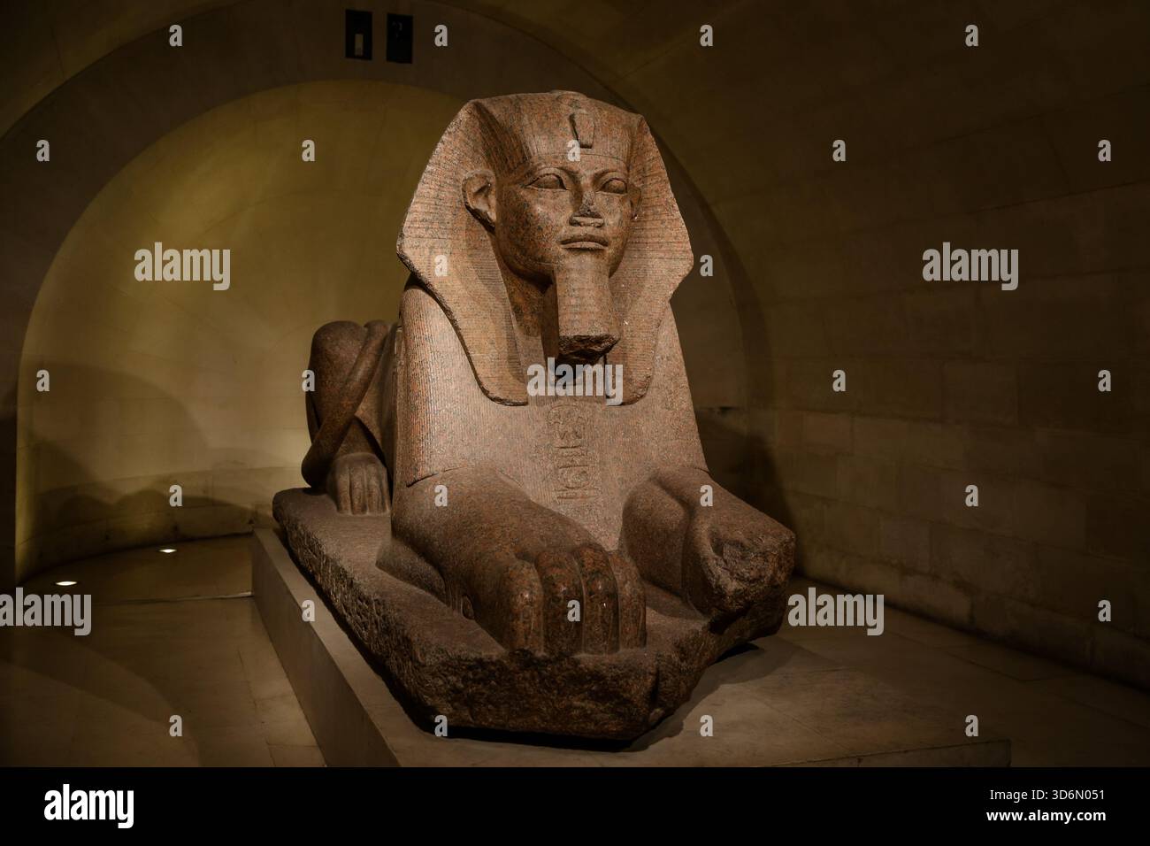 L'antica grande Sfinge egiziana di Tanis esposta nel Museo del Louvre di Parigi, illuminata all'interno della galleria di pietra della collezione di antichità. Foto Stock