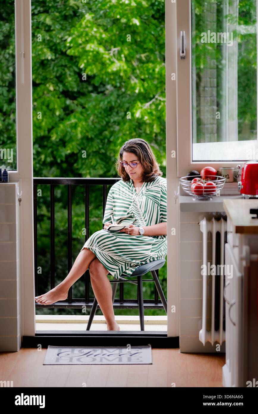 Diari di donne a piedi nudi sul balcone accanto alla cucina aperta Foto Stock