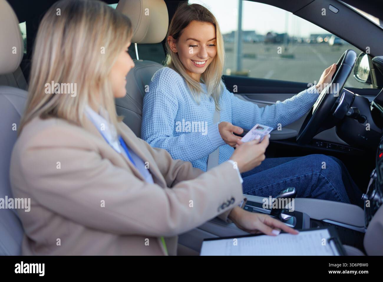 Studente conducente che mostra l'ID all'esaminatore prima del test di guida Foto Stock
