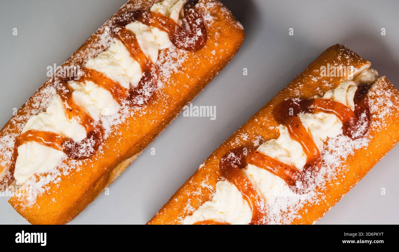 Ciambella soffice ripiena di panna liscia e ricoperta di glassa fresca di fragole e pezzi. Colorato, dolce e perfetto per promozioni e caffetterie. Foto Stock