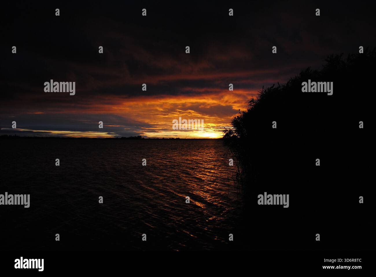 Incredibile gioco di colori con nuvole ardenti al tramonto sul lago Velence in Ungheria Foto Stock