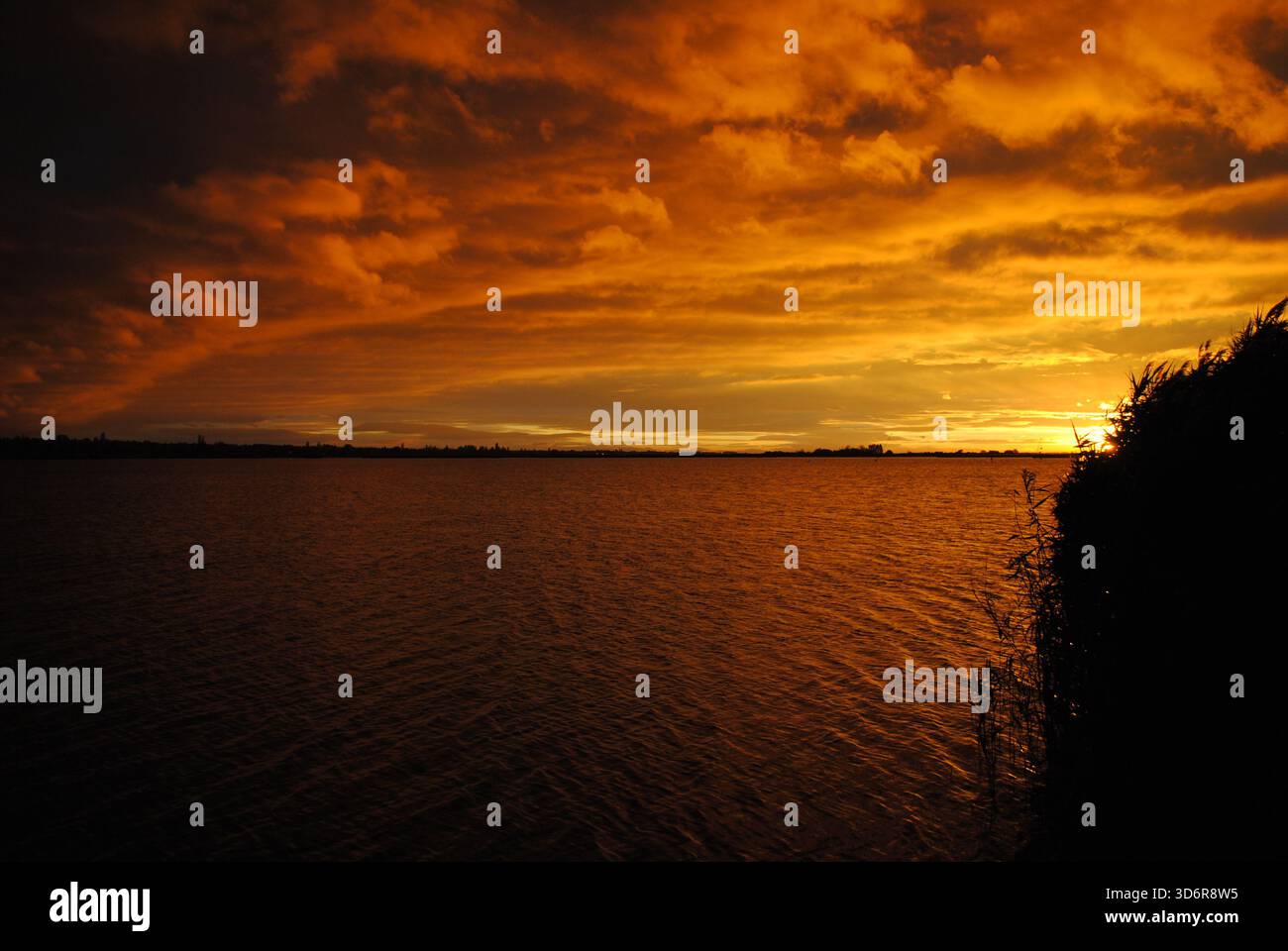 Incredibile gioco di colori con nuvole ardenti al tramonto sul lago Velence in Ungheria Foto Stock