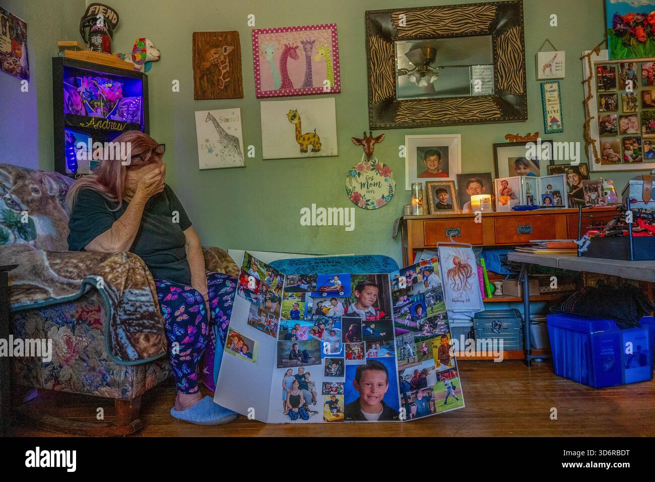 19 maggio 2025, Sacramento, CA: Cheryl Pringle è sopraffatta dall'emozione mentre siede sotto le ceneri del suo SonÂ, che poggiano su una libreria sopra di lei a sinistra, circondata da foto del suo memoriale e candele bruciate in sua memoria, due anni dopo la sua morte, lunedì 19 maggio 2025, a Sacramento. Dice che si sveglia quasi ogni notte in lacrime, sapendo che non lo rivedrà mai più. œHe amava le candele, amava incenseâ tutto quello che amavo, amava, â diceva Â. (Credit Image: © Renée C. Byer/ZUMA Press Wire) SOLO PER USO EDITORIALE! Non per USO commerciale! Foto Stock