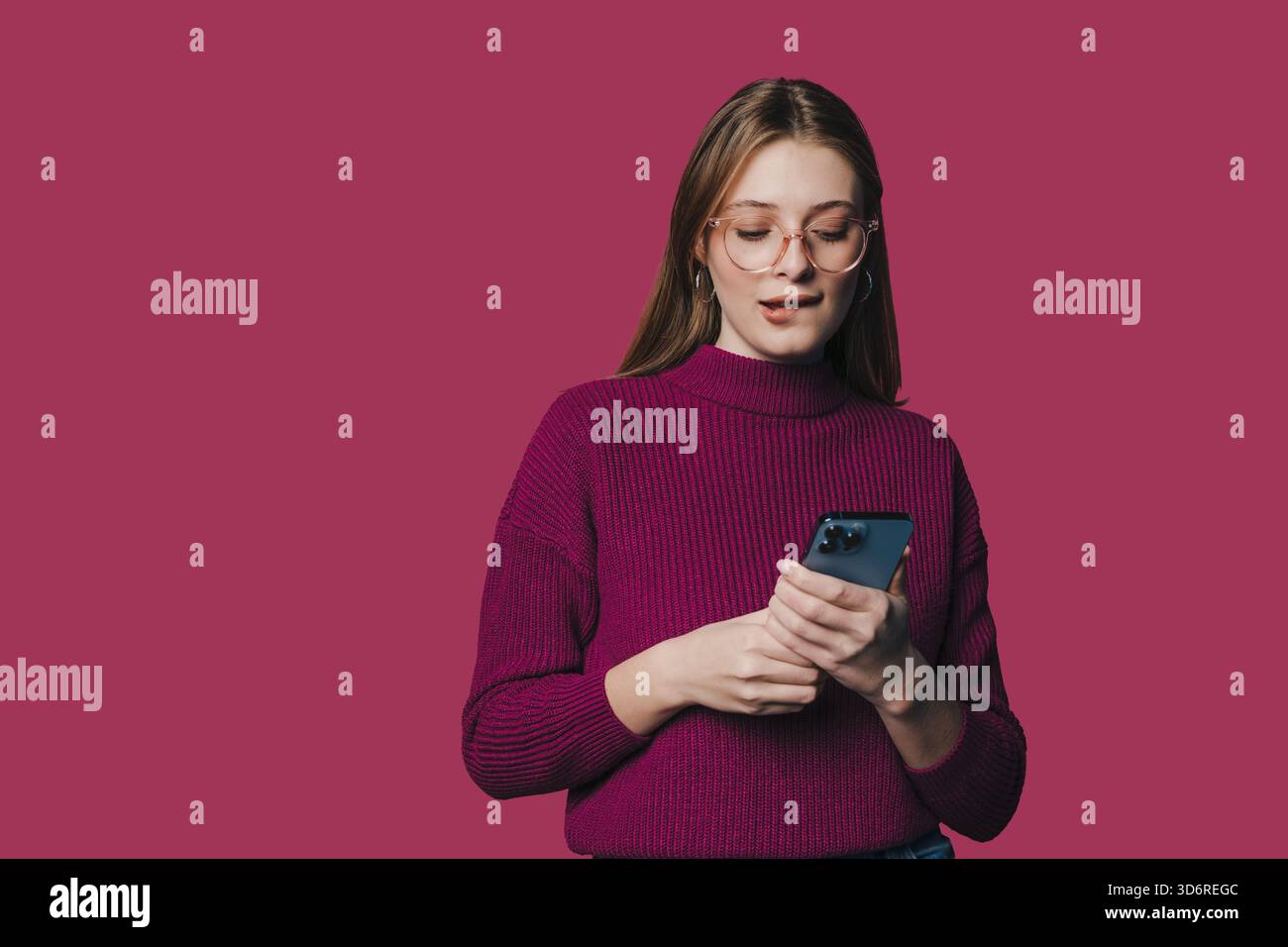 Ritratto interno di una donna in un abbigliamento casual che sfoglia messaggi sullo smartphone Foto Stock