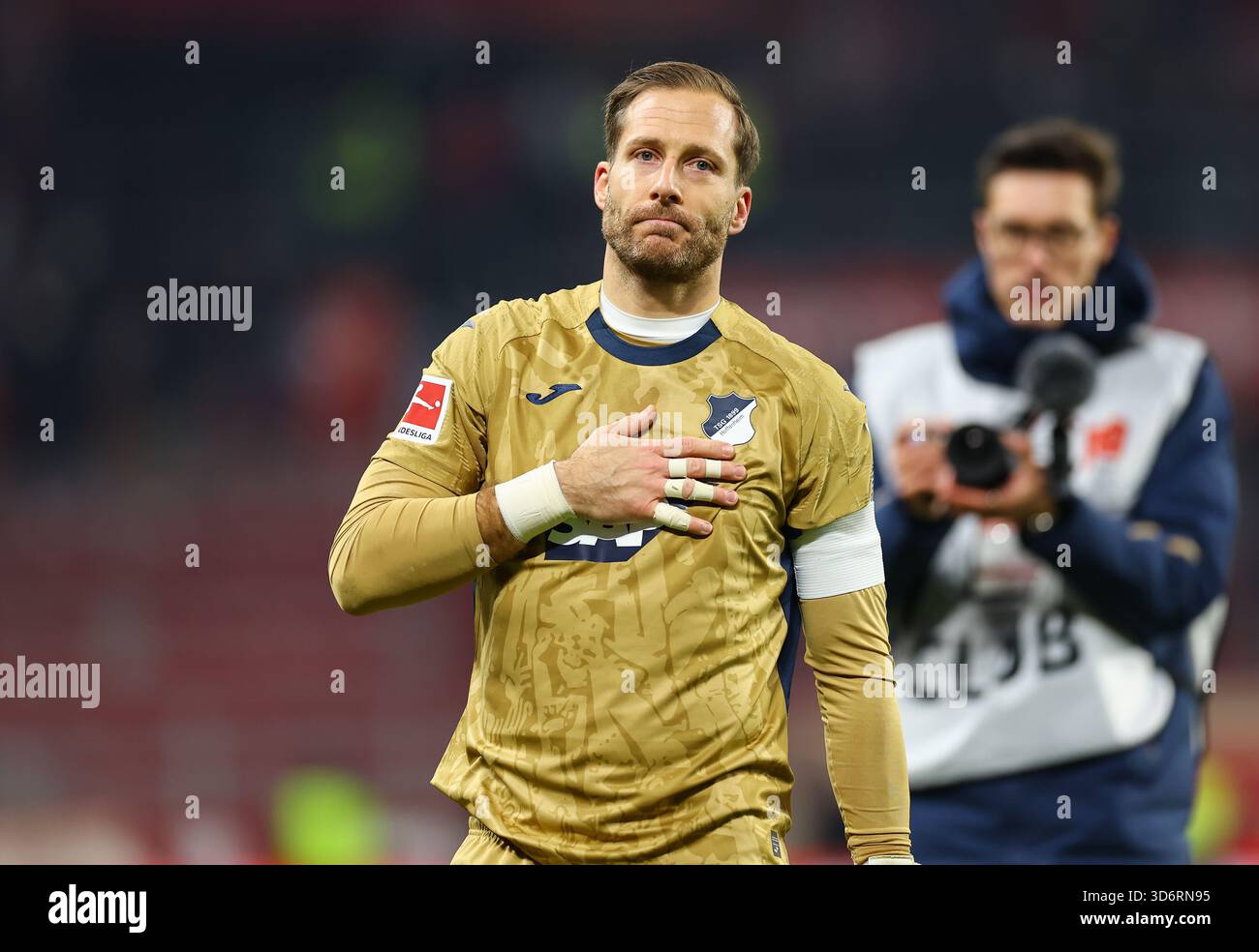 21 novembre 2025, Bundesliga di calcio [Bundesliga], FSV Mainz 05 - TSG 1899 Hoffenheim, emonline, emspor, da sinistra, portiere [portiere] Oliver Baumann (TSG 1899 Hoffenheim) viene celebrato dai tifosi [tifosi] dopo la sua 500a partita competitiva Foto Stock