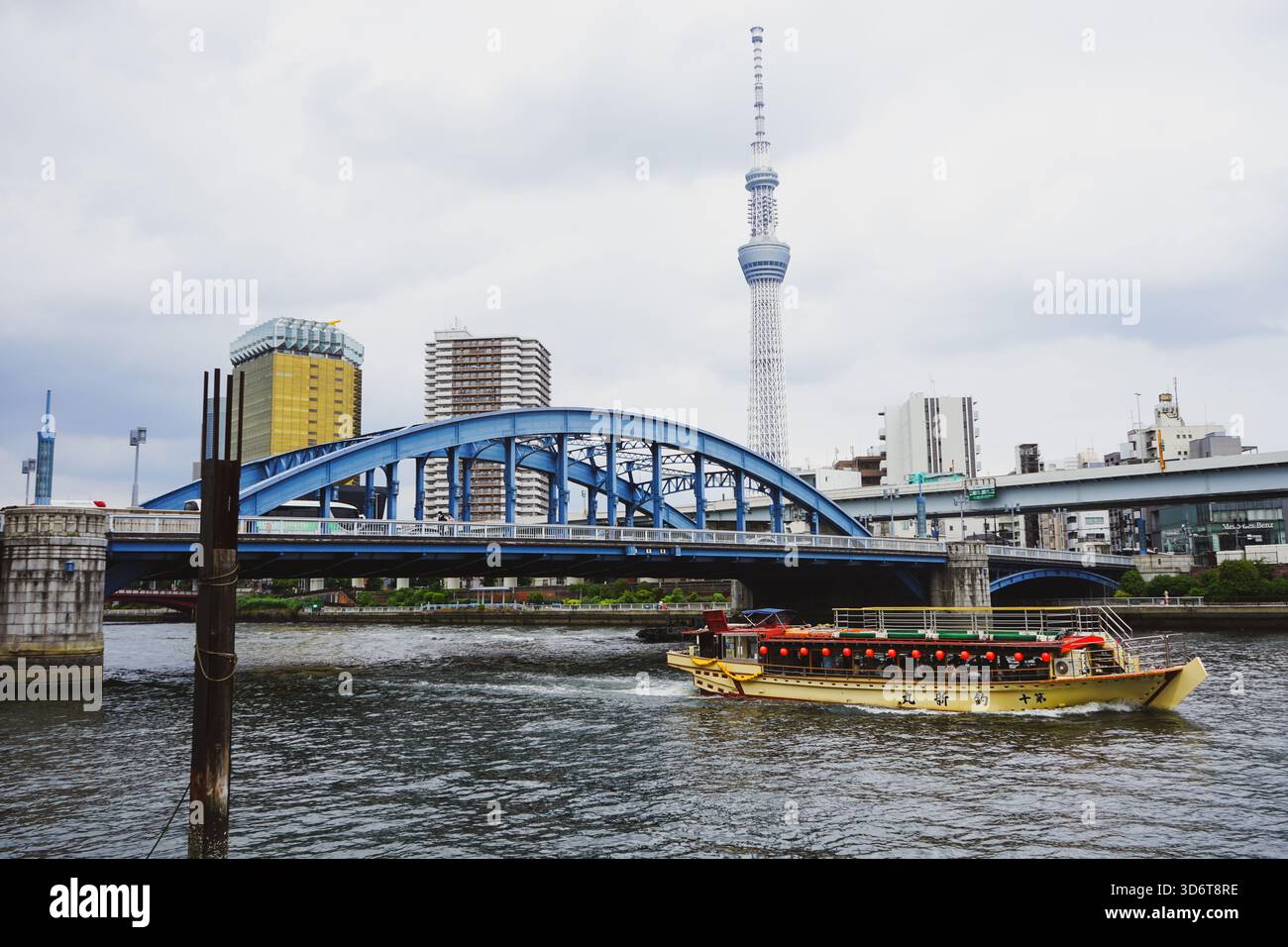 Il tour in barca della città passa sotto il ponte Komagata-bashi sul fiume Sumida con il Tokyo Skytree alle spalle nella città di Sumida, Tokyo, Giappone Foto Stock