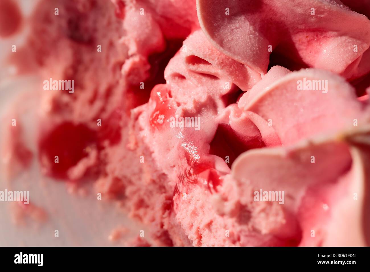 Sciogliere il gelato alla fragola in primo piano alla luce del sole Foto Stock