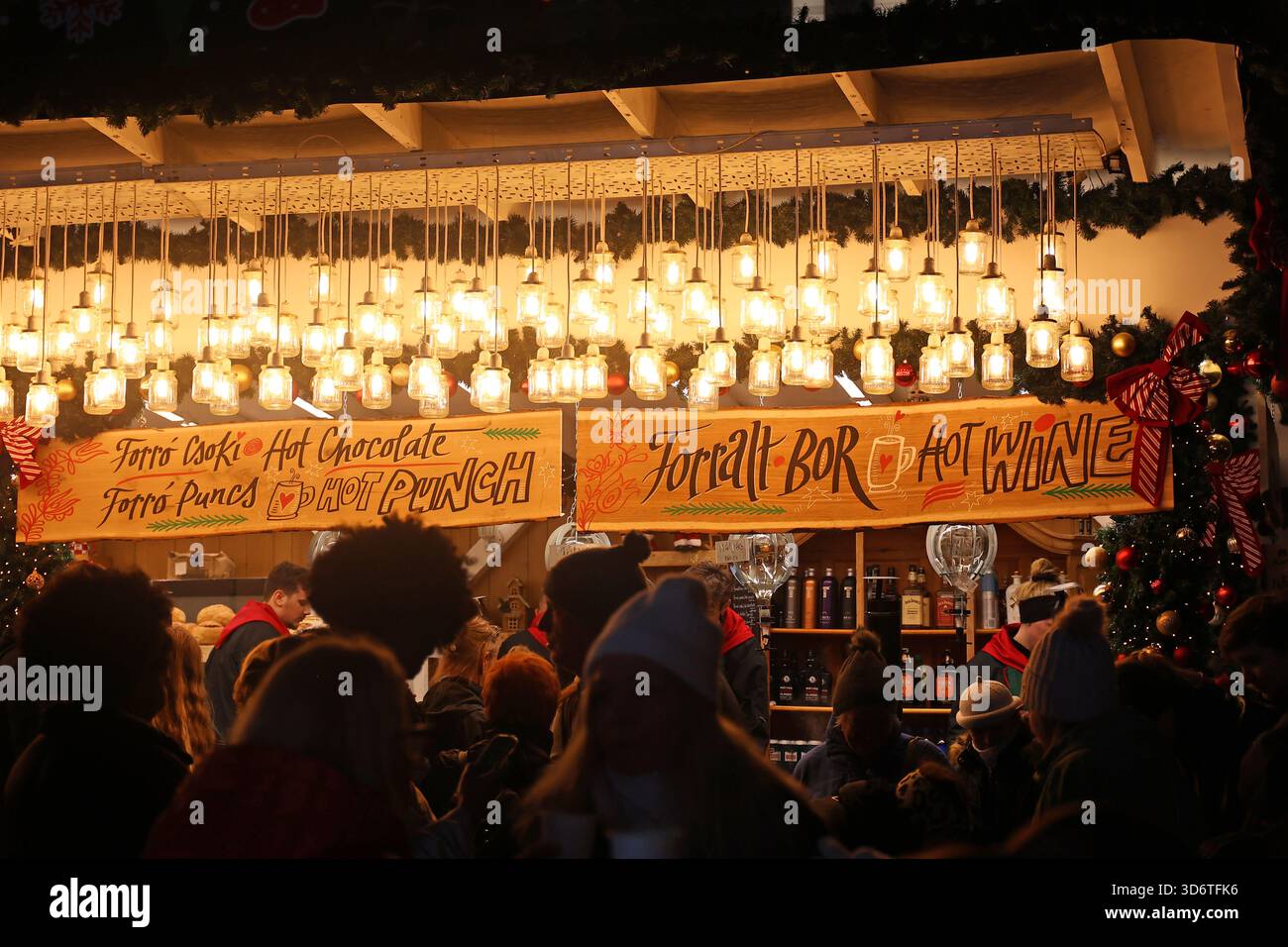 Bancarello decorato che vende VIN brulé e altre bevande calde al mercatino di Natale in serata a Budapest, Ungheria Foto Stock