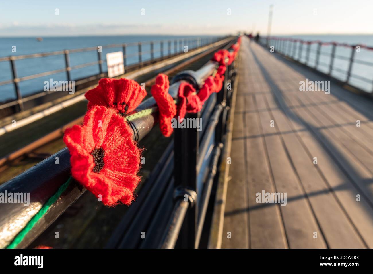 Papaveri sul Pier Remembrance Memorial, mostra di papaveri lavorati a maglia sul Southend Pier, nell'estuario del Tamigi. Papaveri lungo il binario del passaggio pedonale Foto Stock