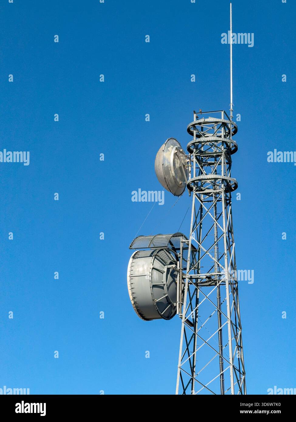Montante per telefono cellulare non contrassegnato e antenne isolate contro un cielo blu. Foto Stock