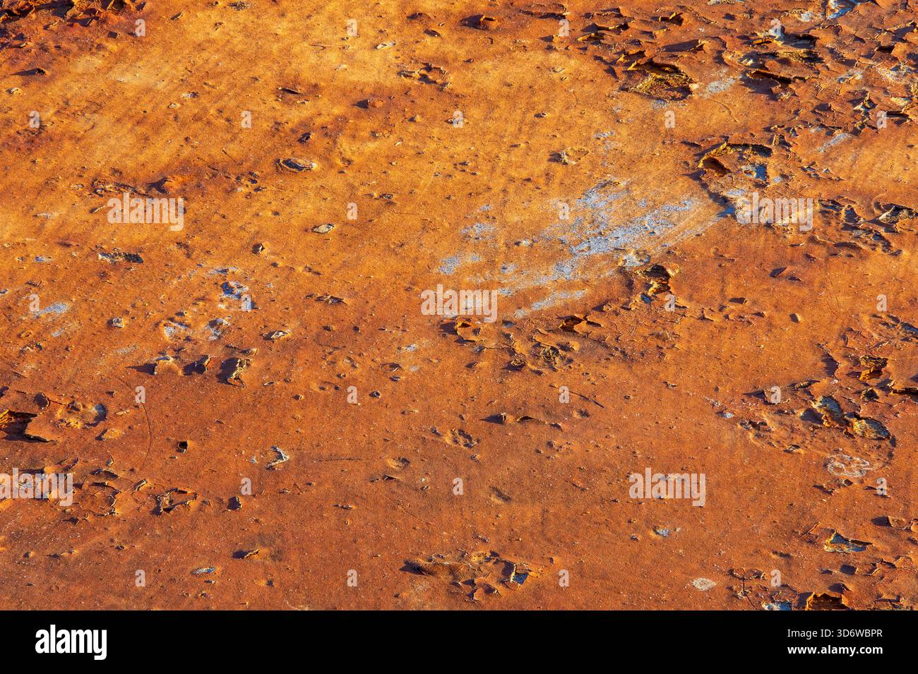 Primo piano di ruggine resistente agli agenti atmosferici con strati di pelatura e patina arancione calda, sfondo industriale dettagliato. Foto Stock